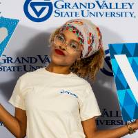 individuals smiling with tan i am grand valley shirt
